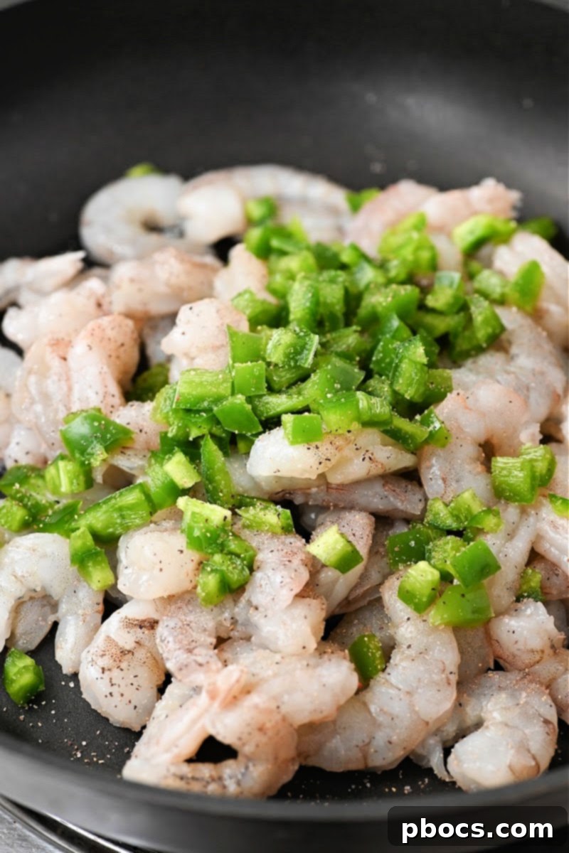 Mixing shrimp with diced jalapenos
