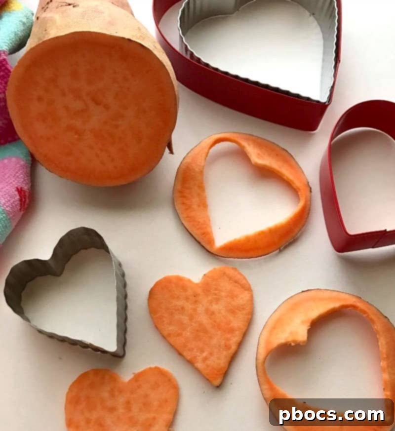 Slicing sweet potatoes into even rounds before cutting into heart shapes.