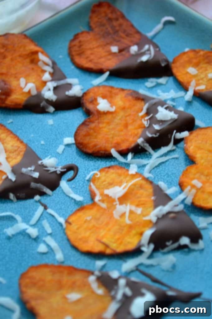 Chocolate-dipped sweet potato hearts being sprinkled with shredded coconut.