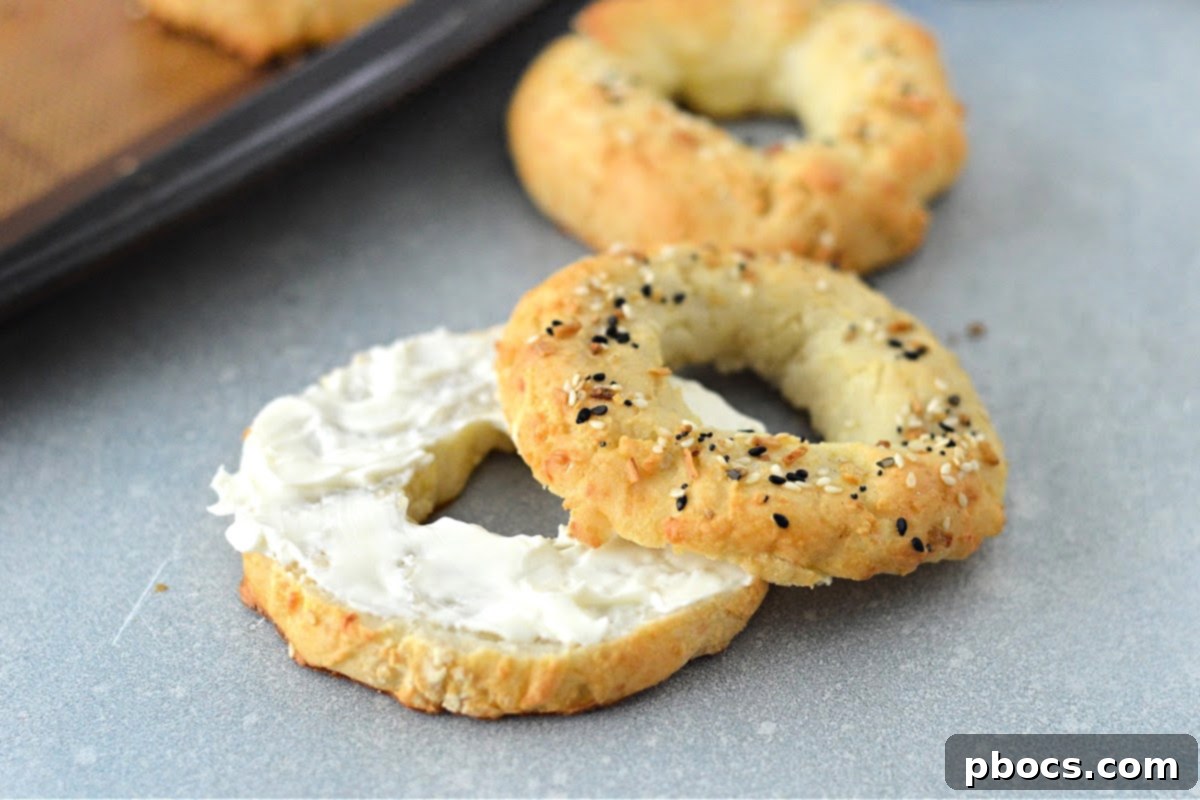 Two perfectly baked Keto Cottage Cheese Bagels, one sliced, ready to be enjoyed.
