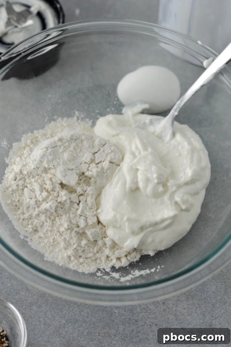 Smooth cottage cheese being added to a bowl of keto self-rising flour.