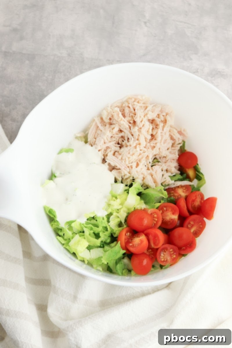 Mixing salad ingredients for the chicken bacon ranch cups filling