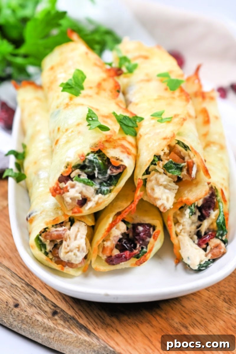 Crispy Low Carb Cranberry Pecan Chicken Roll Ups, garnished with fresh herbs