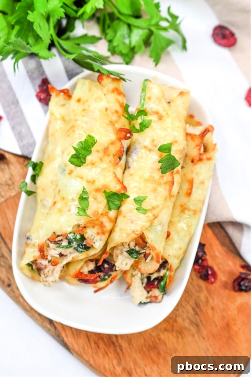 Baked cheese wraps filled with cranberry pecan chicken, ready to be rolled