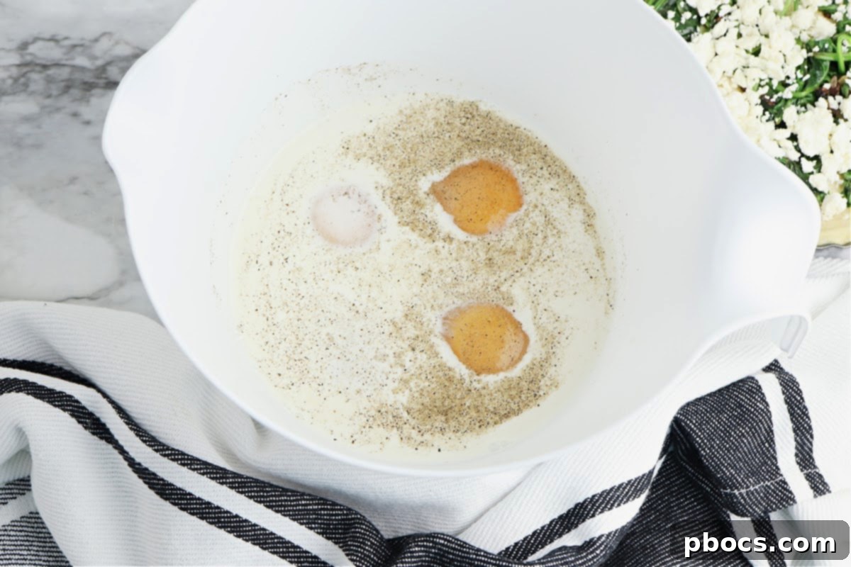 Mediterranean Keto Spinach Feta Bake 9 Mixing bowl with quiche ingredients.