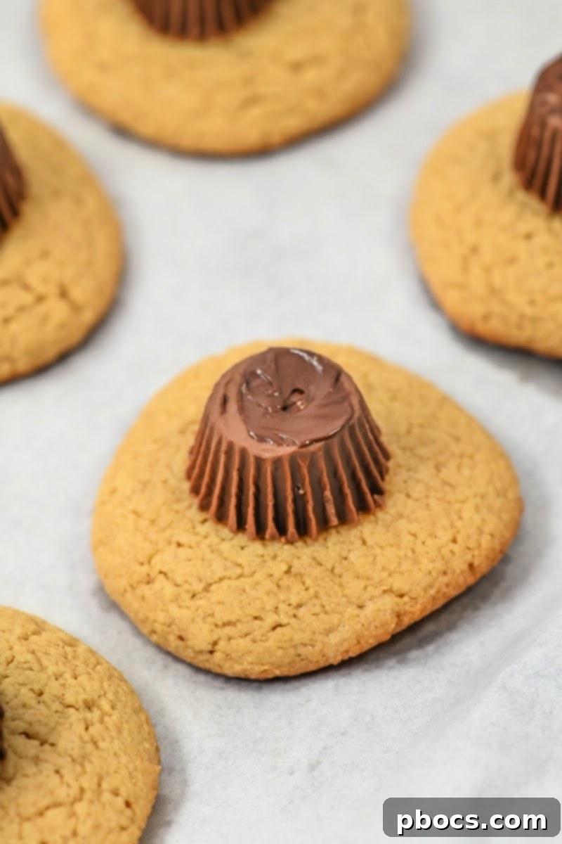 Adding peanut butter cup on top of cookies
