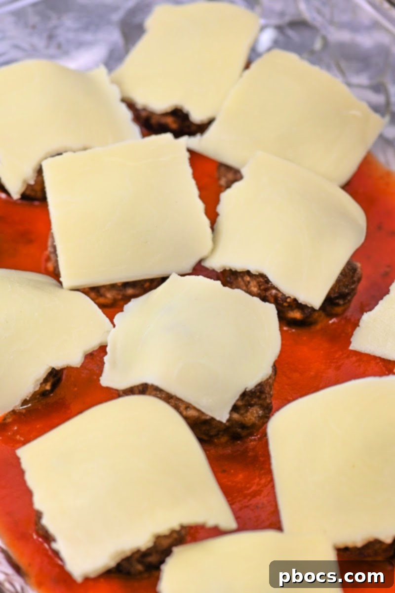 Mozzarella cheese slices cut into quarters and placed on top of each meatball