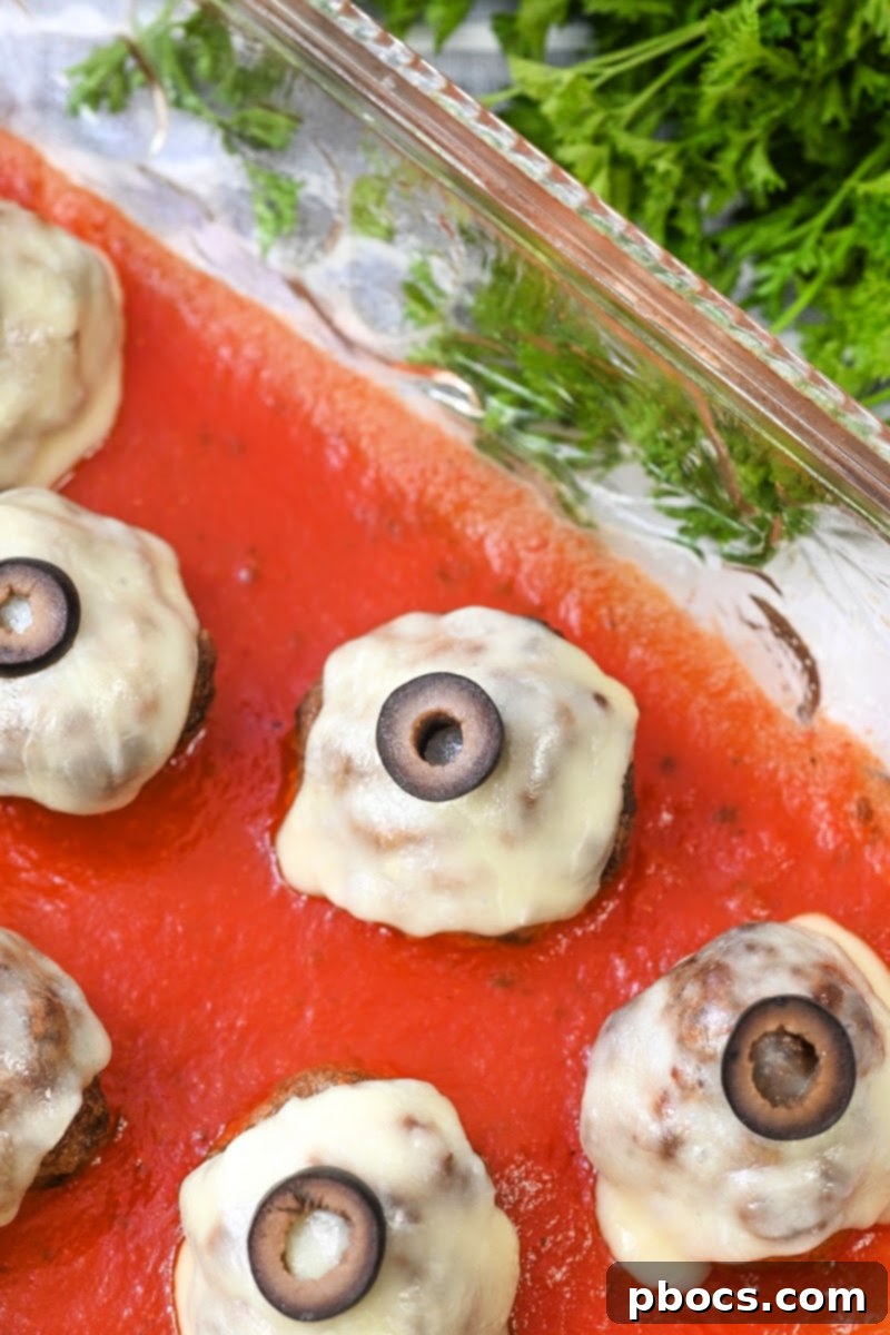 Close-up of a single Keto Meatball Eyeball, showcasing the melted cheese and olive