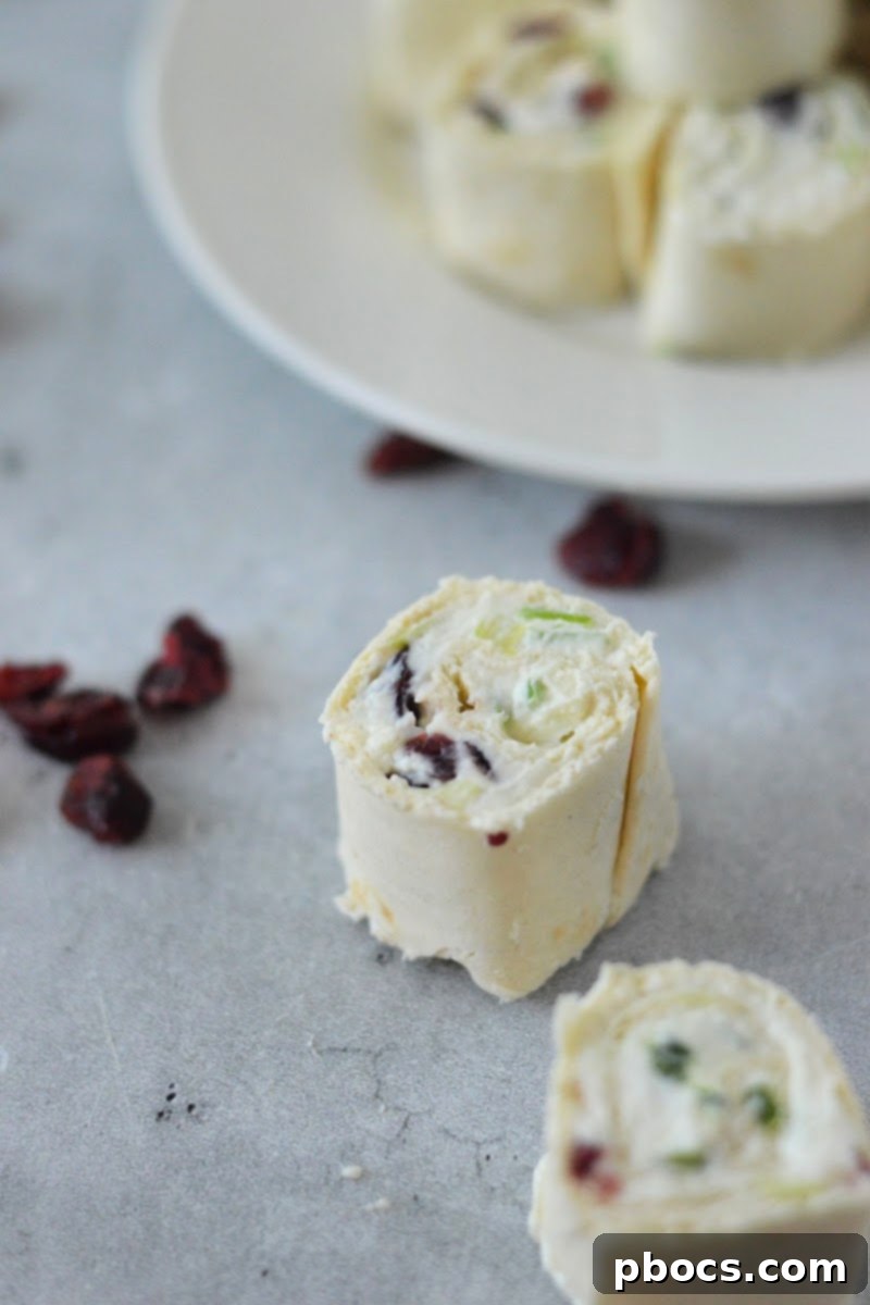 Platter of sliced Low-Carb Cranberry Cream Cheese Pinwheels, garnished and ready for serving at a party.