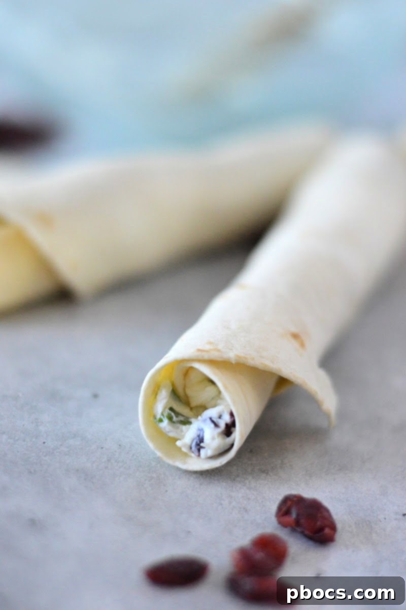 Freshly sliced Low-Carb Cranberry Cream Cheese Pinwheels on a cutting board, ready for serving or storage.