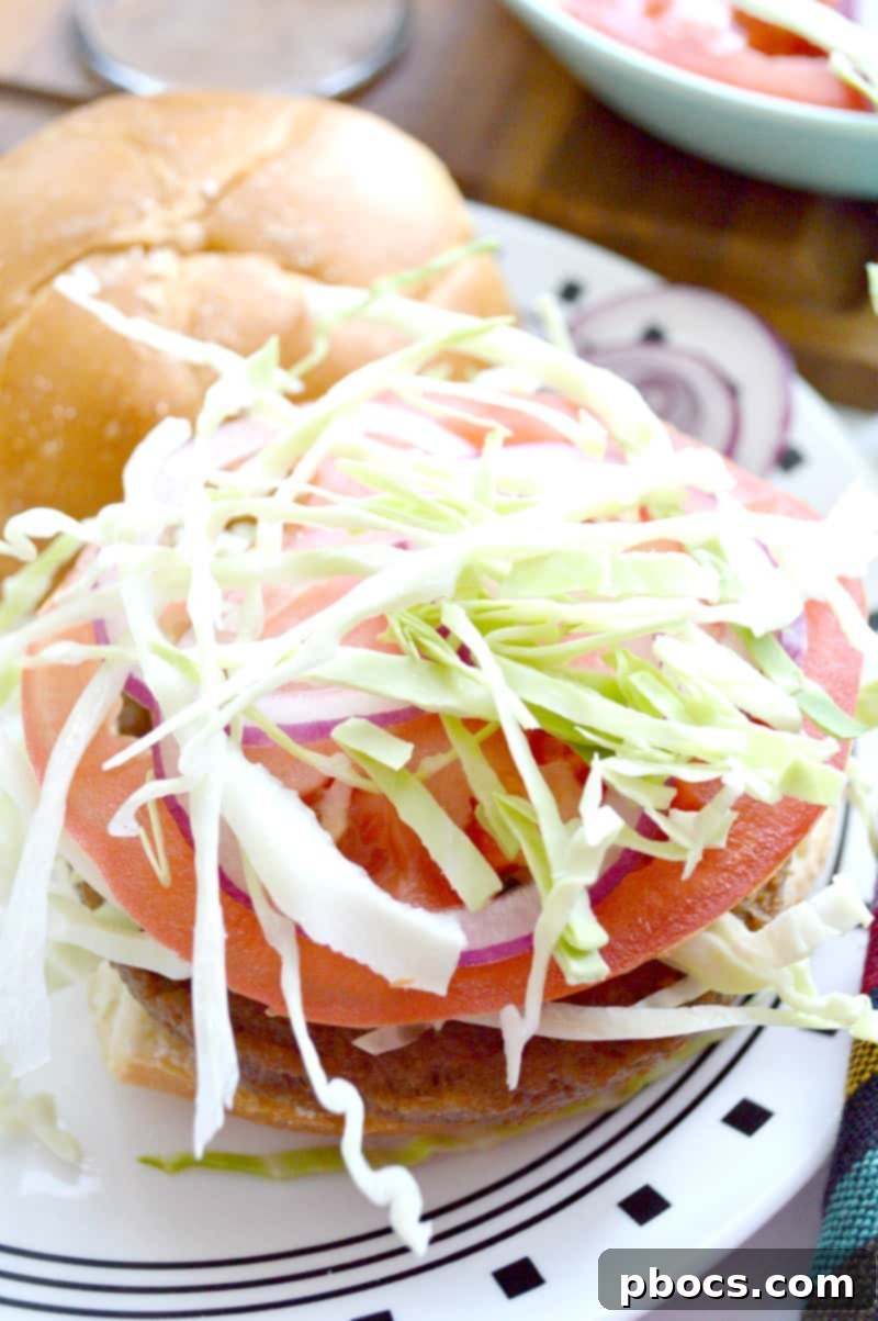 Assembling a vegetarian Chimi burger with patty, cabbage, onions, and tomatoes