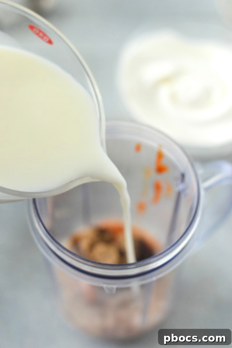 Adding ingredients to a blender for the Low-Carb Pumpkin Spice Latte