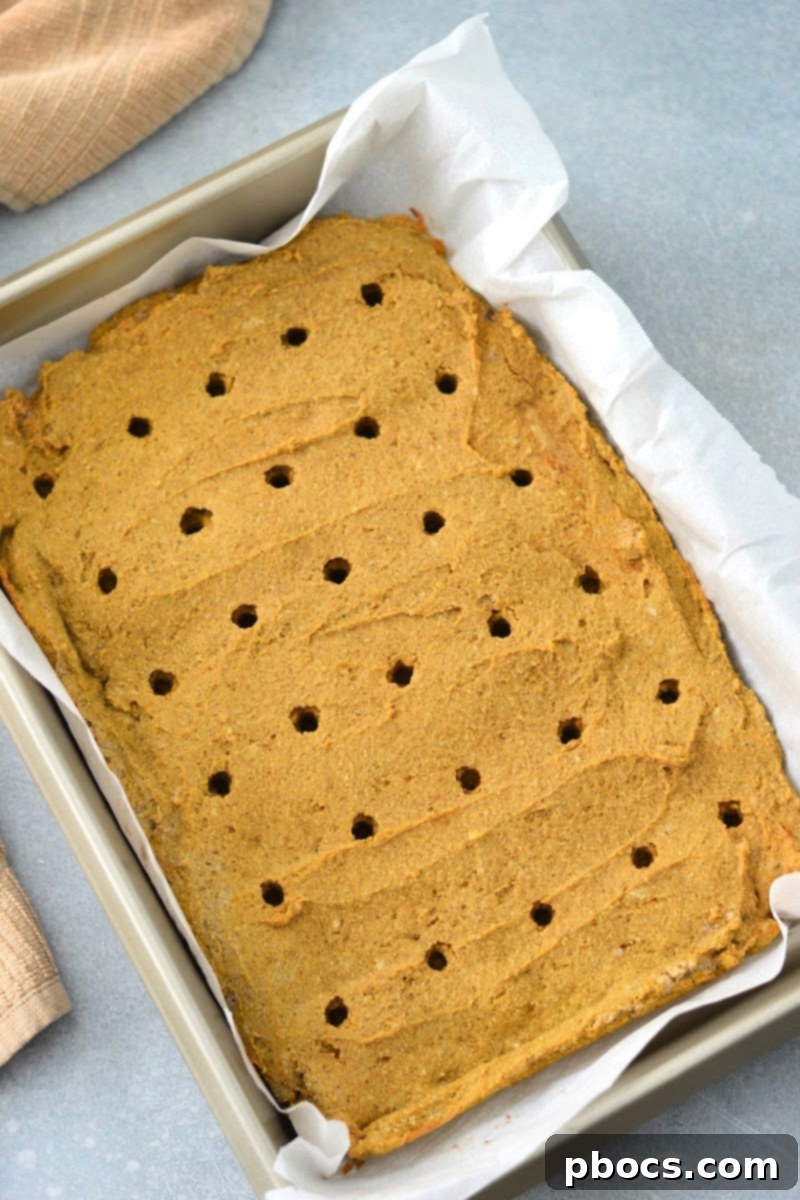 Poking holes into the warm low-carb pumpkin cake with a chopstick