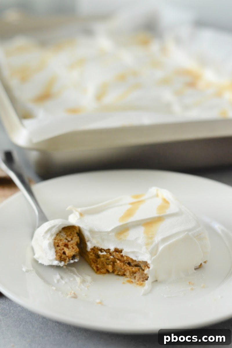 Slice of Low-Carb Pumpkin Poke Cake with whipped topping and caramel drizzle