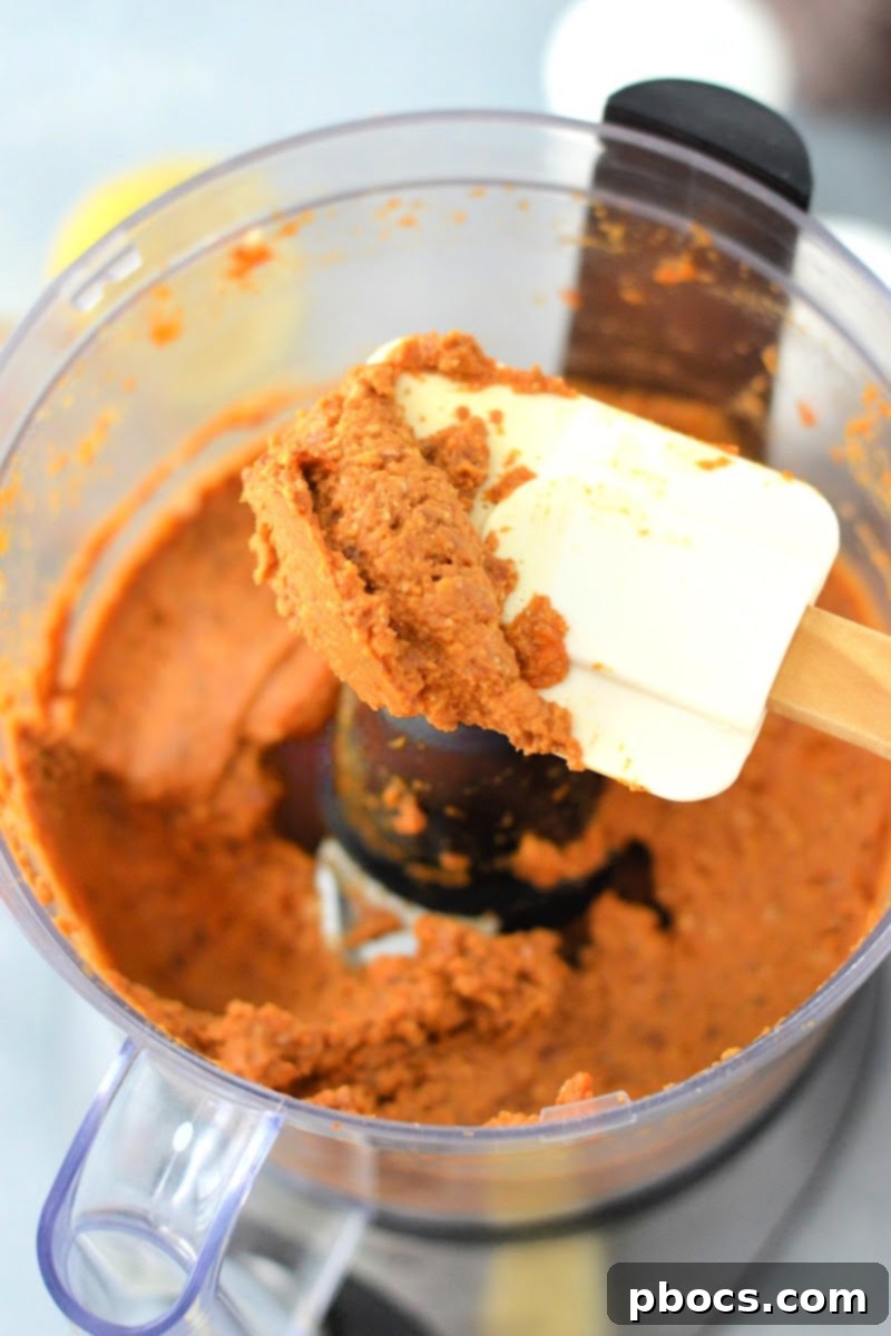 Creamy Keto Pumpkin Veggie Dip 9 Scooping pureed dip from the food processor