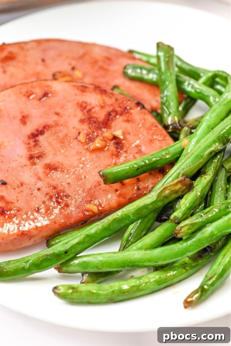 One-Pan Keto Honey-Glazed Ham and Green Beans 2 Keto Honey Glazed Ham and Green Beans Skillet, perfectly seared ham with vibrant green beans in a pan