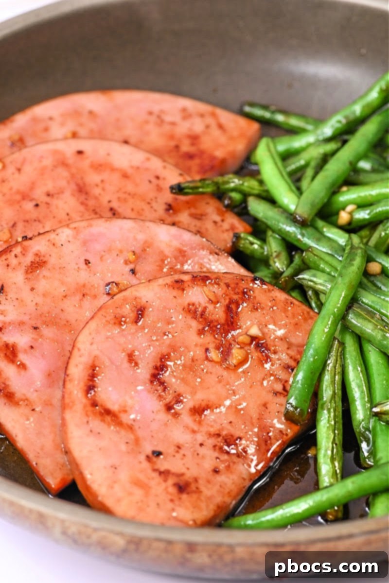 One-Pan Keto Honey-Glazed Ham and Green Beans 3 Close-up of a keto honey glazed ham steak with fresh green beans in a skillet