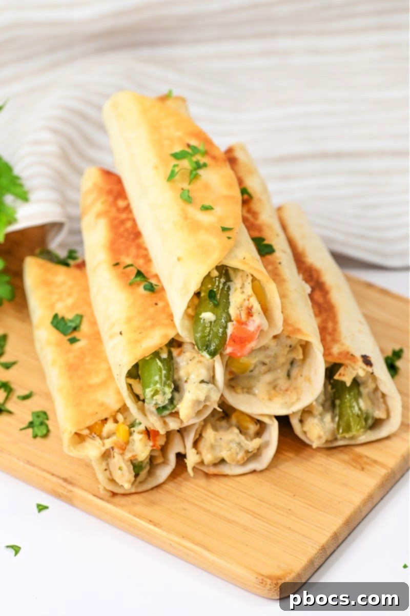 Close-up of a stack of golden brown chicken pot pie roll-ups.