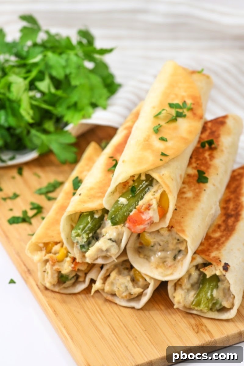 Close-up of a single crispy chicken pot pie roll-up, showcasing its golden exterior.