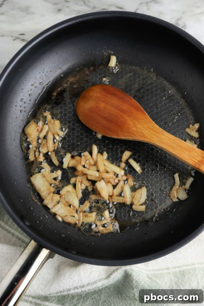 Creamy Keto Pumpkin Lasagna Spirals 9 Sautéing onions in a skillet for lasagna filling