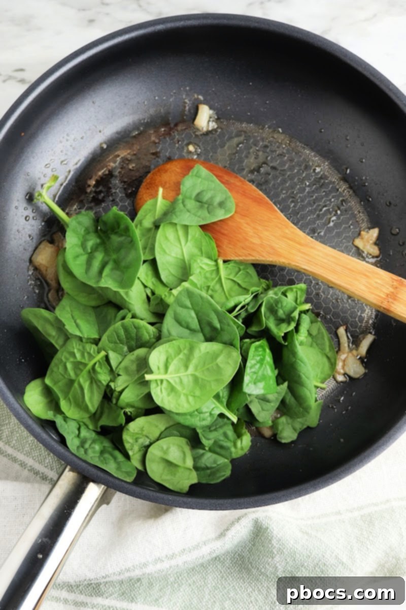 Creamy Keto Pumpkin Lasagna Spirals 10 Adding and sautéing spinach in the skillet