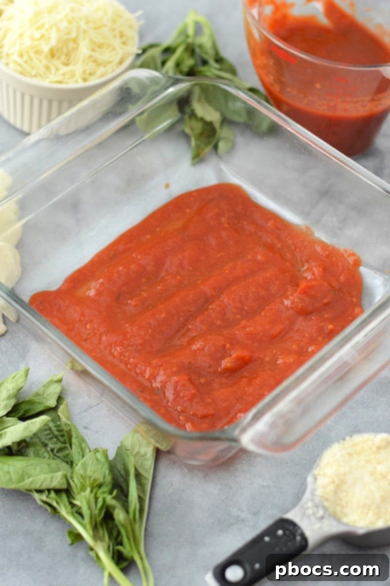 Keto Chicken Parmesan Nugget Bake 9 Marinara sauce spread at the bottom of a baking dish