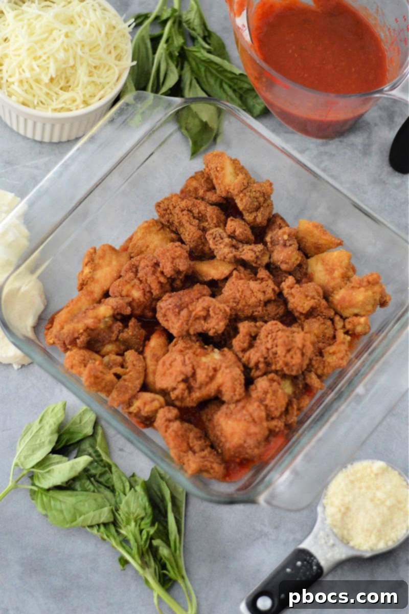 Keto Chicken Parmesan Nugget Bake 10 Keto chicken nuggets arranged over marinara sauce in a baking dish