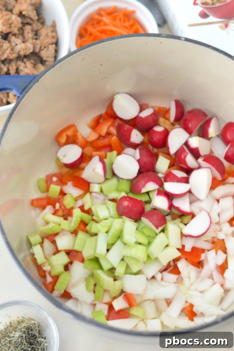 Chopped raw vegetables including onion, bell pepper, celery, and turnip