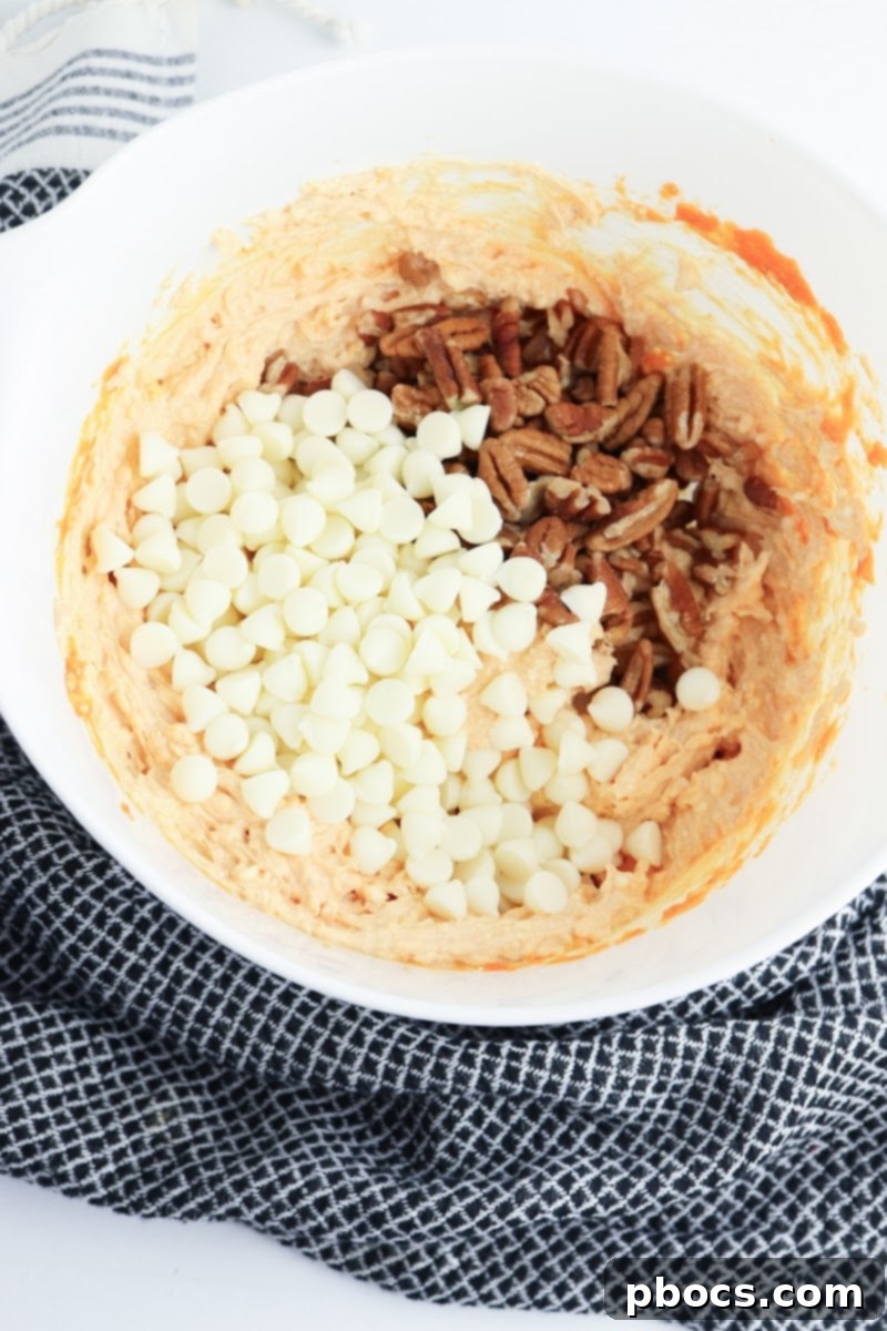 Low-Carb Turtle Pumpkin Cheesecake Bars - Folding in chips and pecans