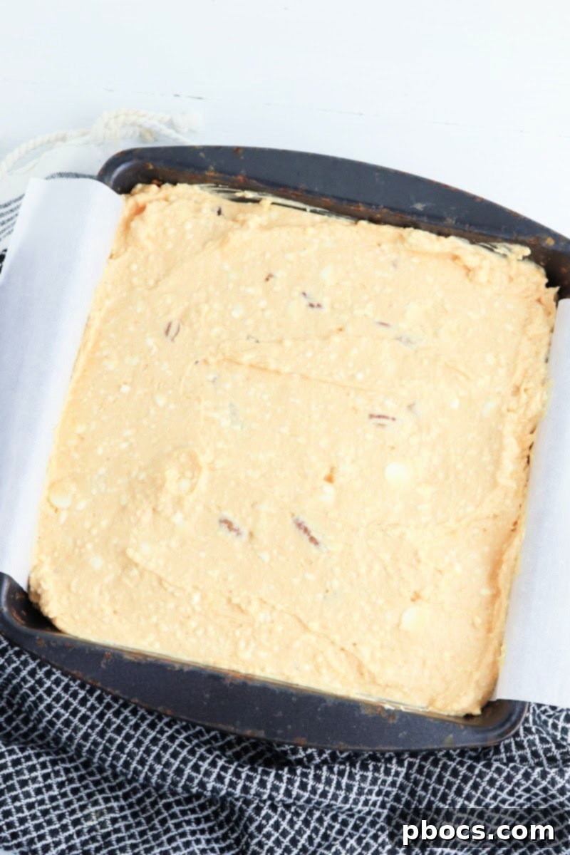 Low-Carb Turtle Pumpkin Cheesecake Bars - Spreading filling over crust