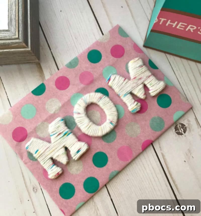 Arranging and gluing the DIY yarn letters inside the decorated shadow box