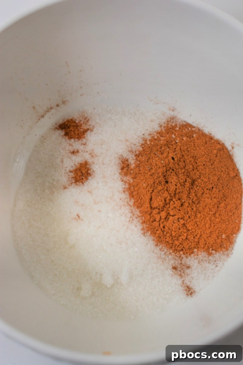 Stirring together Swerve granulated sugar substitute and cinnamon in a small bowl.