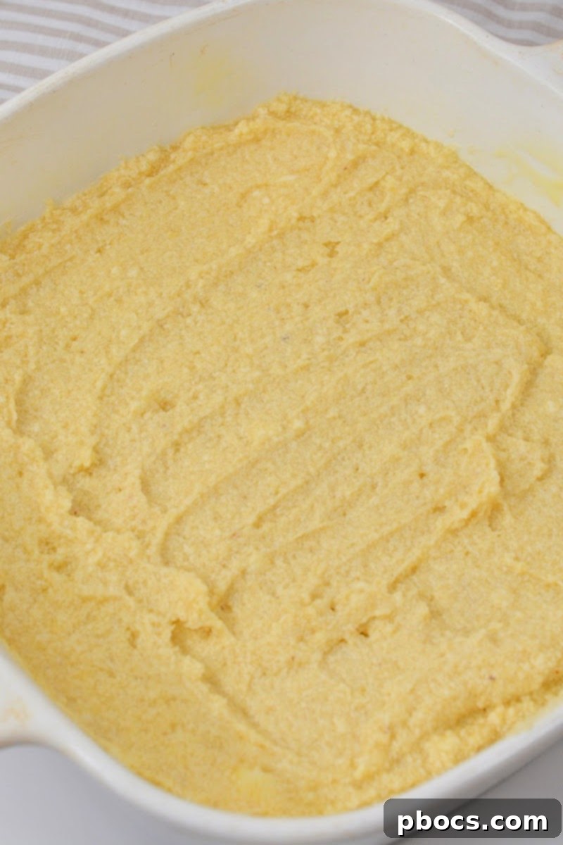 Spreading the snickerdoodle batter evenly into a 9x9 inch baking dish.