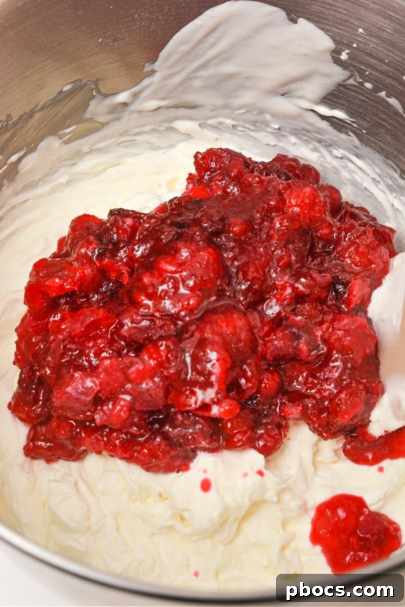 Folding cranberries into whipped cream and cream cheese mixture