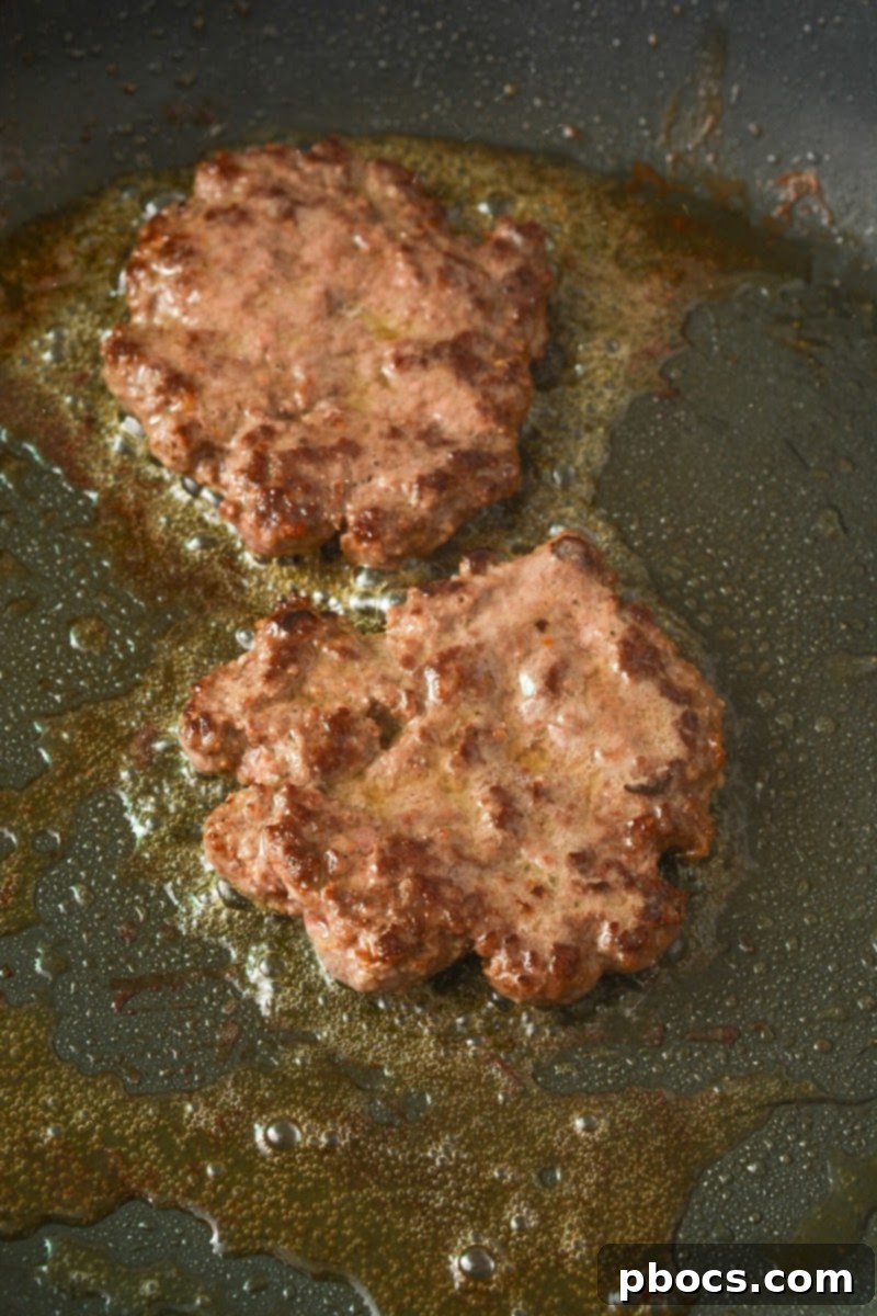 Smashing burger patties on a hot skillet for a crispy crust