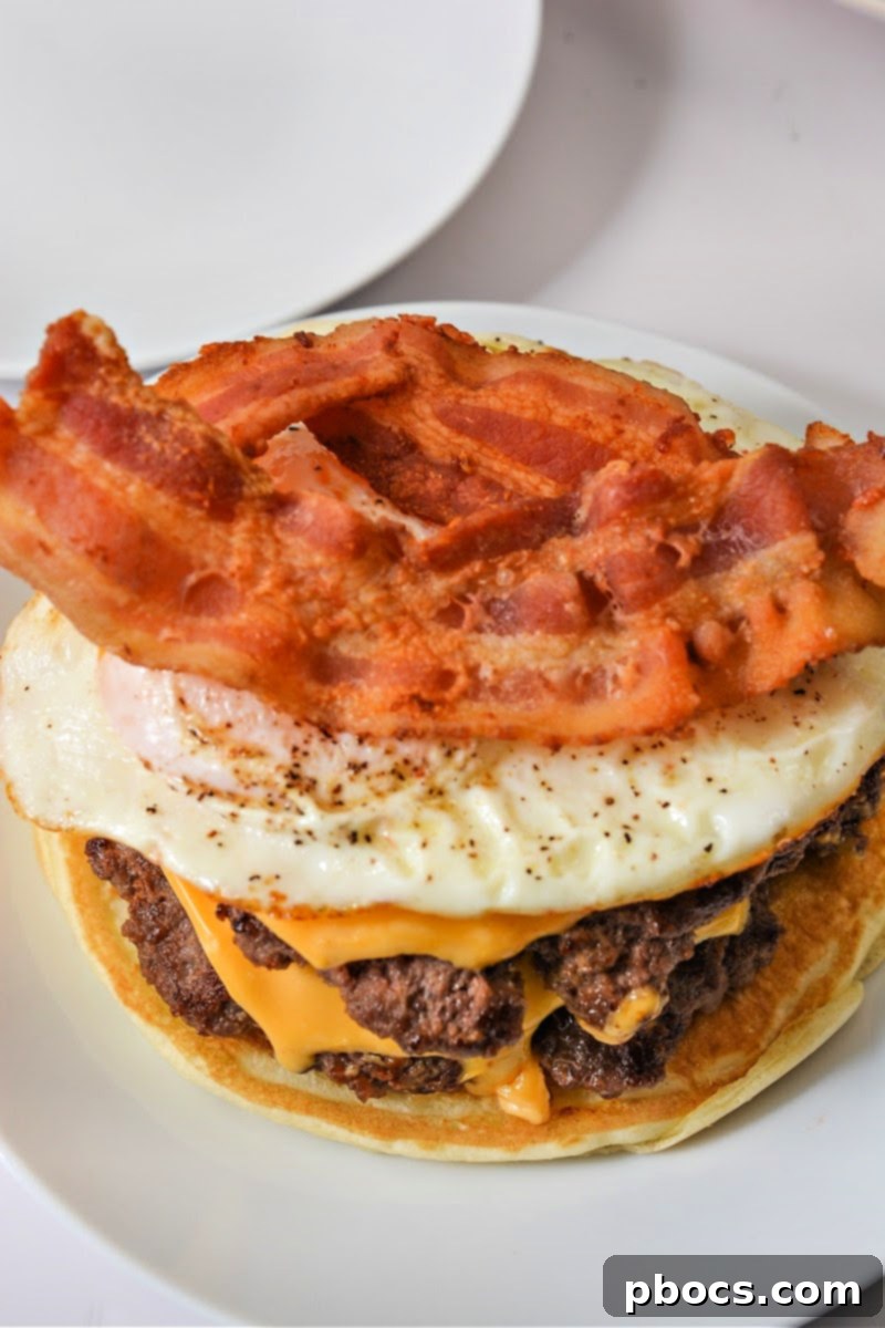 Adding crispy bacon and a fried egg to a breakfast smashburger