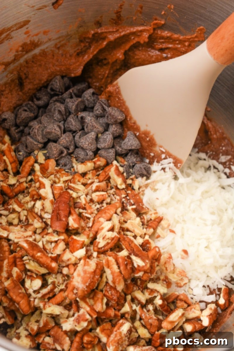 Folding in pecan pie muffin ingredients into the batter