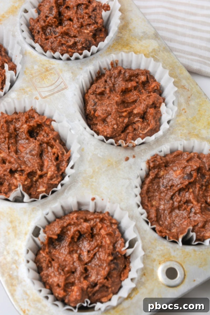 Chocolate Pecan Pie Muffin batter in a muffin tin ready to bake