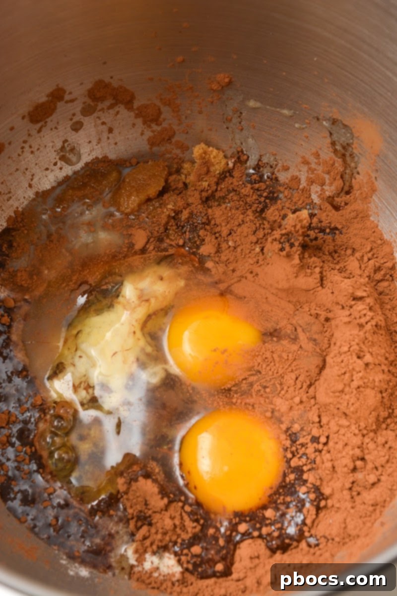 Adding eggs to the cocoa powder mixture for keto muffins