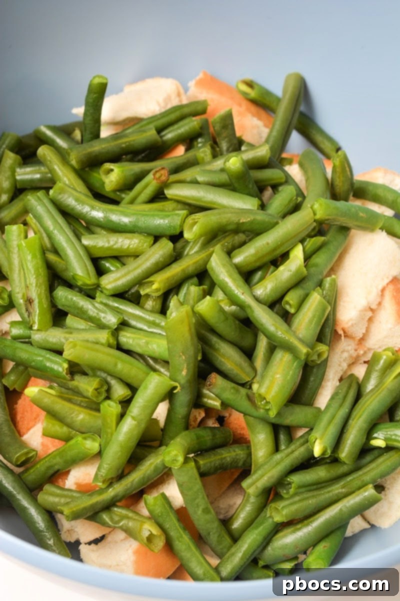 Combining green beans, turkey, and keto bread cubes