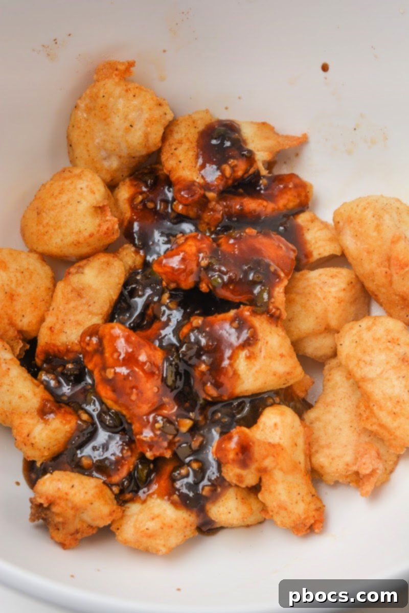 Keto Sweet Chili Chicken Delight 10 Adding sauce to the cooked chicken