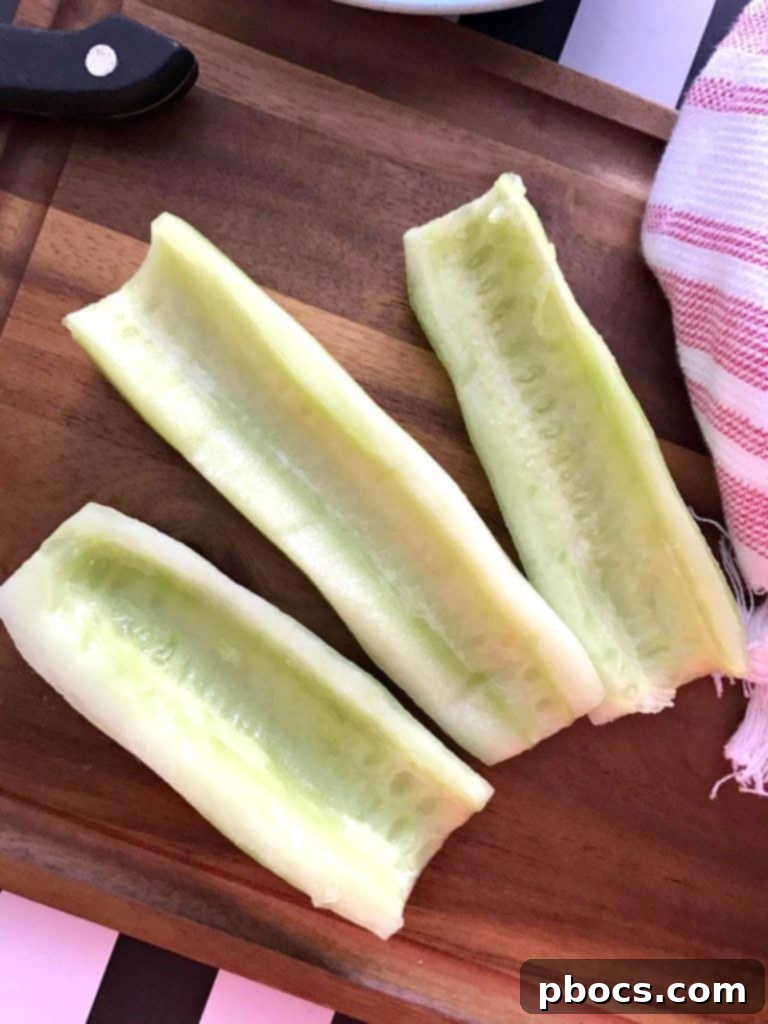 Crisp Cucumber Zesty Feta Jalapeno Kick Salad 4 Hands preparing cucumbers, slicing them after removing seeds, illustrating a step in the salad making process.