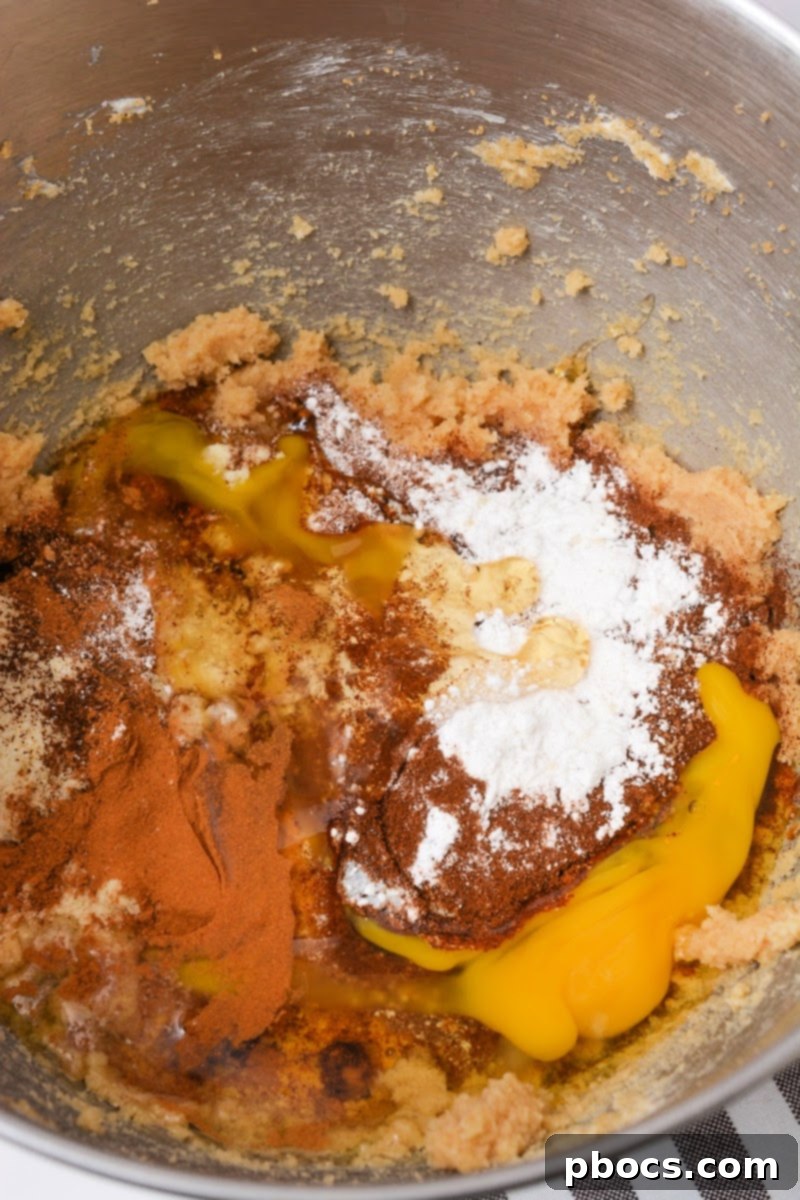 Adding dry ingredients for the cookie dough into a mixing bowl
