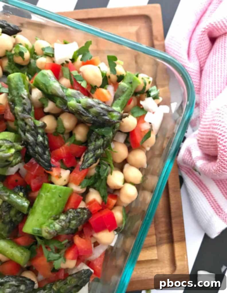 Drained and rinsed chickpeas added to the bowl with vegetables.