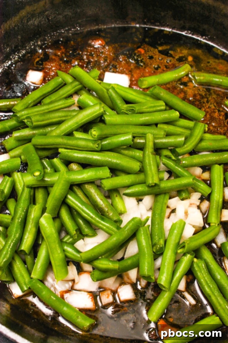 One-Pan Low-Carb Crack Chicken with Green Beans 11 Sautéing green beans and chopped onions in a skillet