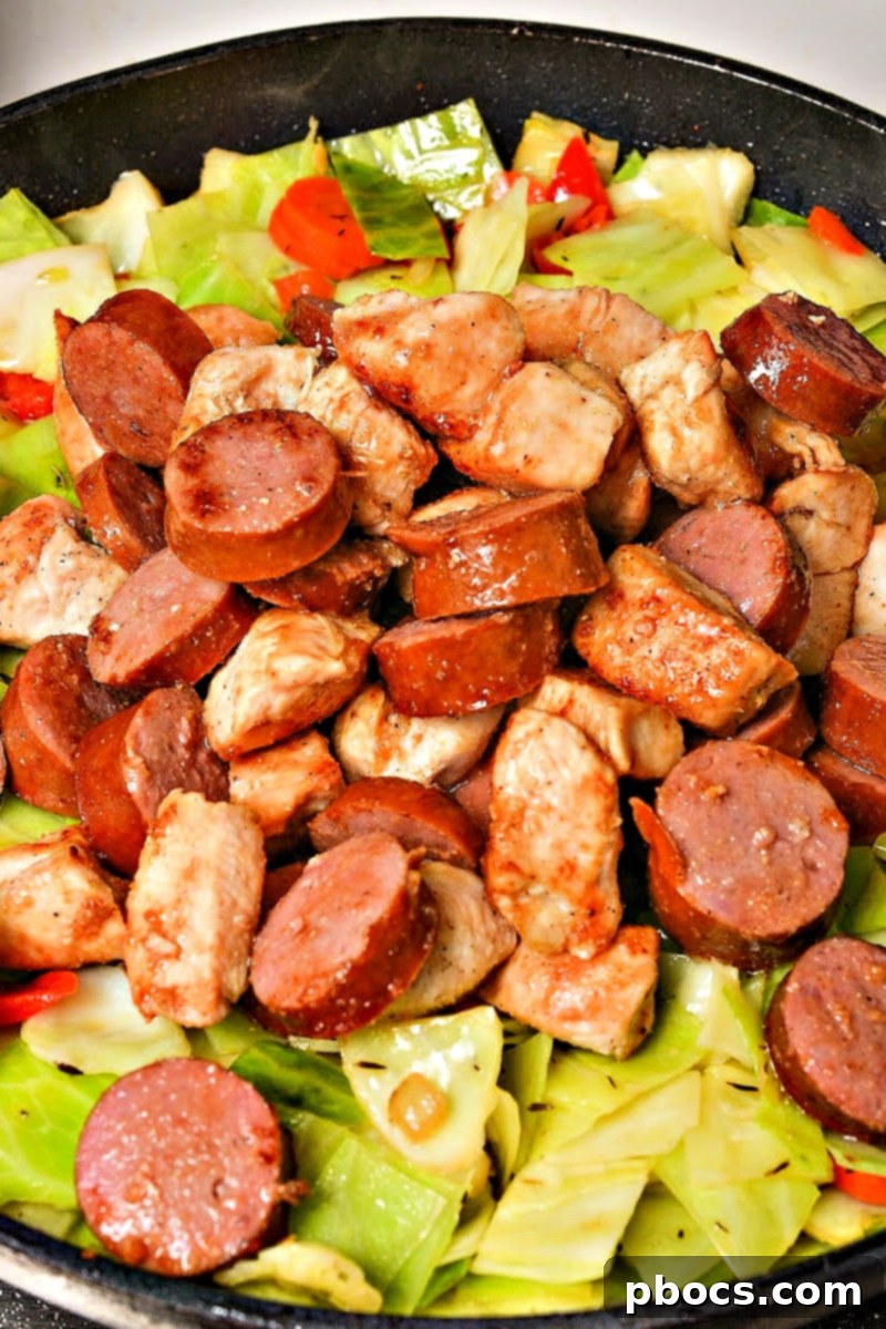 Chopped cabbage and chicken broth added to the skillet with vegetables