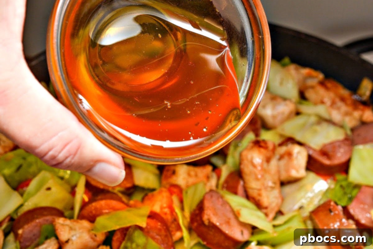 Cooked chicken and sausage added back into the skillet with vegetables