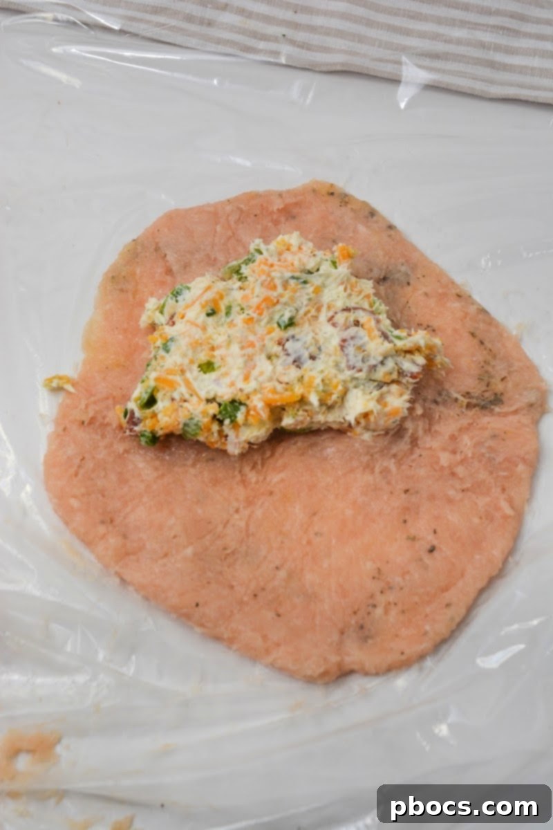 Keto Cheesy Ranch Chicken Pockets 12 Adding a portion of the crack chicken filling to one side of the flattened ground chicken circle