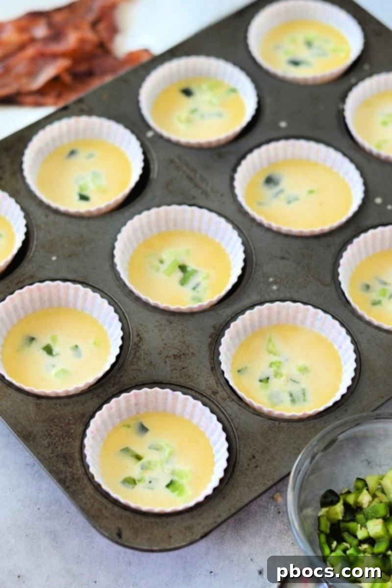 Raw egg batter poured into a muffin tin, ready for toppings.