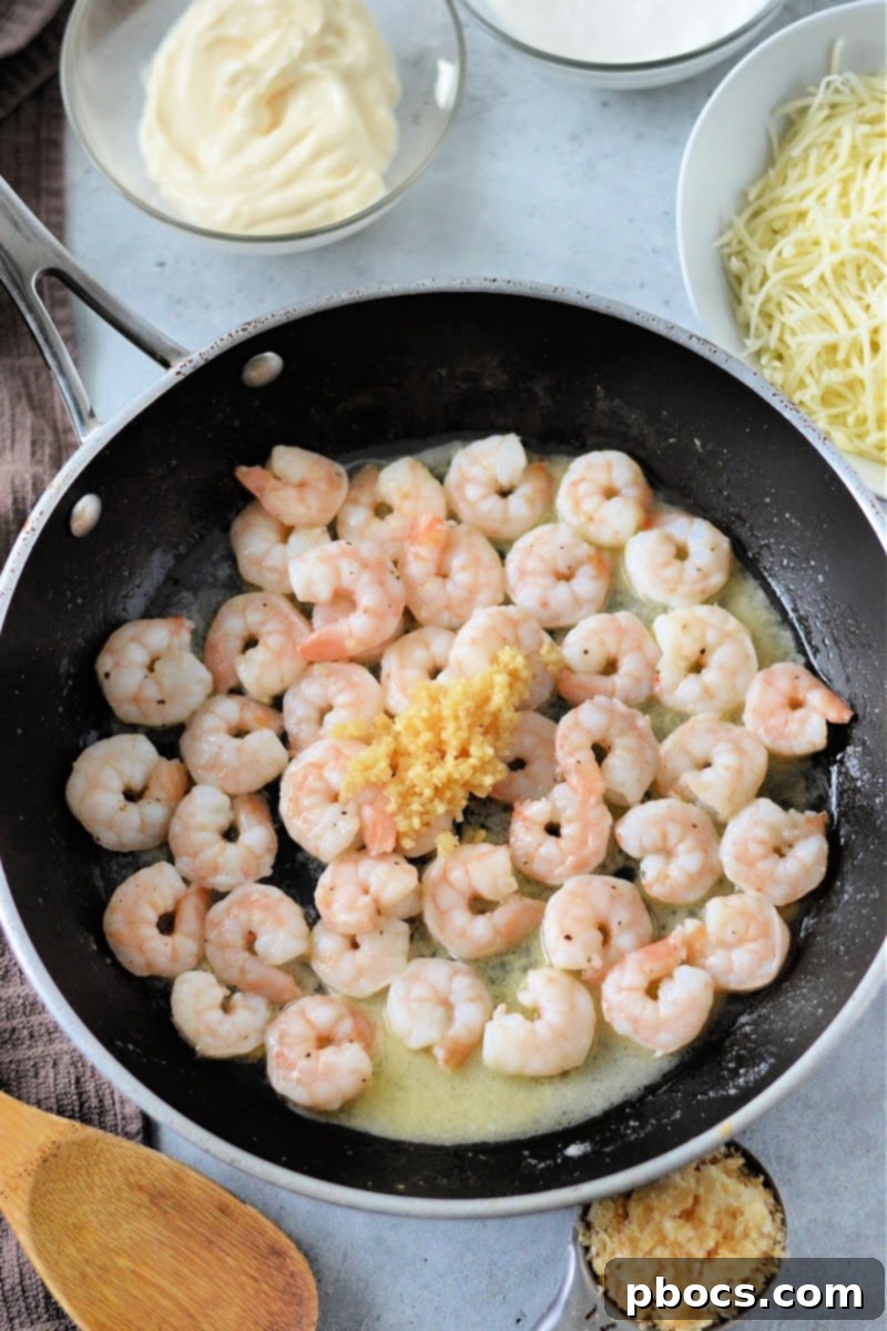 Shrimp cooking in a skillet with minced garlic
